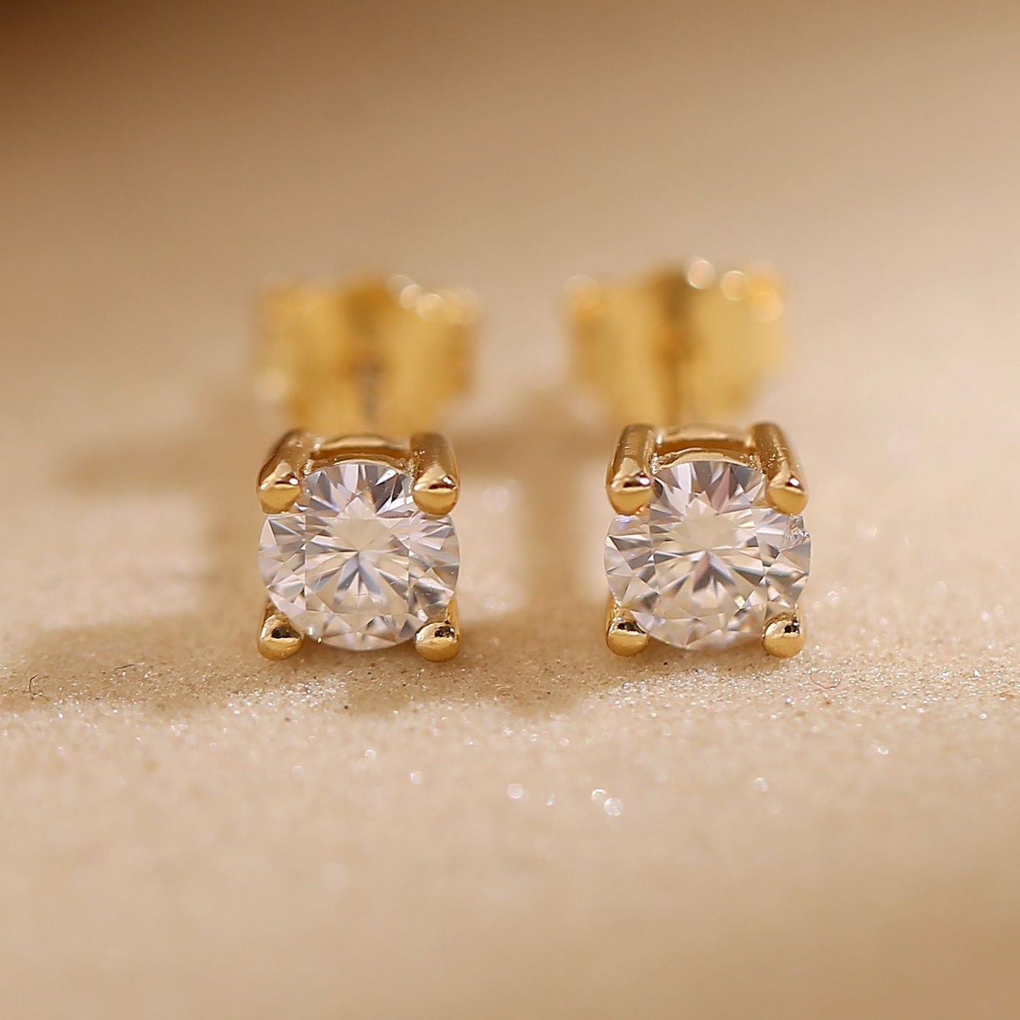 A pair of round-cut moissanite stud earrings set in 18K gold plating, displayed inside an open Symi Jewel branded white jewelry box against a soft fabric background

moissanite stud earrings

18K gold plated earrings

round cut moissanite studs

dainty moissanite earrings

gold moissanite earrings for women

luxury moissanite jewelry

hypoallergenic gold earrings

minimalist moissanite studs

eco-friendly diamond alternative

Symi Jewel earrings

